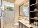 A bathroom showcasing the tile shower, a sink with dark cabinetry and a large mirror at 12448 Highfield Cir, Lakewood Ranch, FL 34202