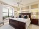 Well-decorated bedroom features a large window seat, a dark wooden bed frame, and neutral tones at 12448 Highfield Cir, Lakewood Ranch, FL 34202