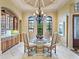 Dining area with chandelier, built-in cabinet, and beautiful views from the arched windows at 12448 Highfield Cir, Lakewood Ranch, FL 34202