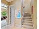 Hallway with neutral tile floors and walls leading to stairs and other rooms at 12448 Highfield Cir, Lakewood Ranch, FL 34202