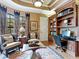 A traditional home office with custom built-in shelving, hardwood floors, and stylish decor and furnishings at 12448 Highfield Cir, Lakewood Ranch, FL 34202
