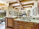 Kitchen with granite countertops and custom cabinets looking into an adjacent Gathering room with a view of the pool at 12448 Highfield Cir, Lakewood Ranch, FL 34202