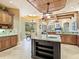 Open-concept kitchen featuring a center island, custom cabinetry, and views of the outdoor dining area at 12448 Highfield Cir, Lakewood Ranch, FL 34202