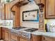 Close-up of the professional-grade gas range with decorative tile backsplash and custom wood accents at 12448 Highfield Cir, Lakewood Ranch, FL 34202