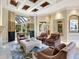 Elegant living room with coffered ceiling, comfortable seating, and view of the pool area at 12448 Highfield Cir, Lakewood Ranch, FL 34202