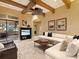 Cozy living room with exposed beams, ceiling fan, and adjacent kitchen and dining area at 12448 Highfield Cir, Lakewood Ranch, FL 34202