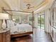 Main bedroom with hardwood floors, a canopy bed, tray ceilings and views of the backyard pool area at 12448 Highfield Cir, Lakewood Ranch, FL 34202