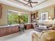 Cozy home office features custom built-ins, a desk with a large window view, and comfortable seating at 12448 Highfield Cir, Lakewood Ranch, FL 34202