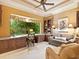 Comfortable home office with custom built-in desk and shelves, a large window, and a seating area at 12448 Highfield Cir, Lakewood Ranch, FL 34202
