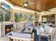Inviting covered outdoor patio with fireplace and complete outdoor kitchen, adjacent to a large pool at 12448 Highfield Cir, Lakewood Ranch, FL 34202