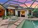 Screened in pool and spa area with brick paver steps and tropical plants at 12448 Highfield Cir, Lakewood Ranch, FL 34202