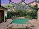 Screened in pool with tropical plants, brick patio and stone steps at 12448 Highfield Cir, Lakewood Ranch, FL 34202