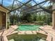 Sparkling pool with lush tropical landscape, complemented by a fully screened enclosure for relaxation and privacy at 12448 Highfield Cir, Lakewood Ranch, FL 34202