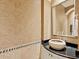 An elegant powder room featuring designer wallpaper, decorative mirror, and a vessel sink on a granite counter at 12448 Highfield Cir, Lakewood Ranch, FL 34202