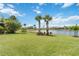 Expansive backyard with vibrant green grass and a serene pond at 13805 Posada St, Venice, FL 34293