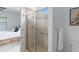 Bright bathroom features a glass enclosed shower with tiled walls and nearby bedroom access at 13805 Posada St, Venice, FL 34293