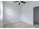 A simple bedroom has grey wood floors, a ceiling fan, and bright lighting at 13805 Posada St, Venice, FL 34293