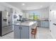 Modern kitchen with stainless steel appliances, island with seating, and granite countertops at 13805 Posada St, Venice, FL 34293