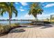 Scenic lake view with a bench, lush landscaping, and walking path, providing a tranquil outdoor space at 13805 Posada St, Venice, FL 34293