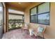 Covered patio with brick floor, stylish seating, and views of lush greenery at 13805 Posada St, Venice, FL 34293