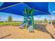 Community playground featuring a covered play structure, slide, and seating with scenic lake views at 13805 Posada St, Venice, FL 34293