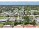 Expansive aerial view of a residential neighborhood with tree-lined streets and a shimmering pond at 1400 62Nd S Pl, St Petersburg, FL 33705