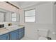 Bathroom with a vanity featuring blue cabinets, gold hardware, and a marble countertop at 1400 62Nd S Pl, St Petersburg, FL 33705
