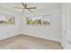 Bright bedroom with wood-look tile flooring, ceiling fan, and two windows offering nice views at 1400 62Nd S Pl, St Petersburg, FL 33705