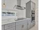 Contemporary kitchen featuring stainless steel appliances, cooktop, and stylish range hood at 1400 62Nd S Pl, St Petersburg, FL 33705