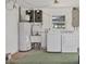 Functional laundry area features a washing machine, dryer, utility sink, and water heater at 1400 62Nd S Pl, St Petersburg, FL 33705