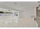 Spacious living area features white tile floors, large windows, and modern ceiling fan at 1400 62Nd S Pl, St Petersburg, FL 33705