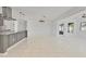 Bright living room with white tile flooring, modern lighting, and neutral walls at 1400 62Nd S Pl, St Petersburg, FL 33705
