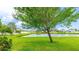 Lush backyard with a scenic pond view, mature trees, and manicured lawn at 1426 Harbour Blue St, Ruskin, FL 33570