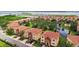 Aerial view of townhouses with terra cotta roofs surrounding a pond at 1512 3Rd Street E Cir, Palmetto, FL 34221