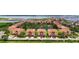 A high-angle shot shows terra cotta-roofed townhouses nestled around a scenic pond and lush trees at 1512 3Rd Street E Cir, Palmetto, FL 34221