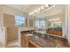 Elegant bathroom offering dual sinks, a soaking tub with jets, a walk-in shower, and tiled accents at 1512 3Rd Street E Cir, Palmetto, FL 34221