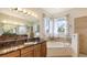 Luxury bathroom showcasing a soaking tub, glass shower, double sinks, and beautiful vanity countertops at 1512 3Rd Street E Cir, Palmetto, FL 34221