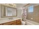 Bright bathroom with a large vanity, decorative mirror, and tiled shower/tub combination at 1512 3Rd Street E Cir, Palmetto, FL 34221