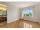 Inviting bedroom with hardwood flooring, a window for natural light, and adjacent access to the bathroom at 1512 3Rd Street E Cir, Palmetto, FL 34221