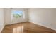 Well-lit bedroom showcasing hardwood floors and a window offering natural light and a view of the trees at 1512 3Rd Street E Cir, Palmetto, FL 34221