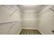 A walk-in closet with a laminate floor and white shelving units at 1512 3Rd Street E Cir, Palmetto, FL 34221