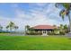 View of community clubhouse with a red tiled roof, manicured lawn, and verdant landscaping at 1512 3Rd Street E Cir, Palmetto, FL 34221