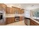 Well-lit kitchen features stainless steel appliances, wood cabinets, and a center island at 1512 3Rd Street E Cir, Palmetto, FL 34221