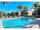 Beautiful community pool with lounge chairs and palm trees under a bright blue sky at 1512 3Rd Street E Cir, Palmetto, FL 34221