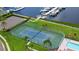 Aerial view of well-maintained tennis courts with a clear view of the marina and boat docks beyond at 1512 3Rd Street E Cir, Palmetto, FL 34221