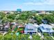 Enjoy this aerial view showcasing a neighborhood home with a pool, putting green, and proximity to city buildings and lush foliage at 1523 1St W Ave, Bradenton, FL 34205