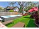 Backyard featuring swim spa, lounge chairs, fire pit, and a manicured lawn for recreation and relaxation at 1523 1St W Ave, Bradenton, FL 34205
