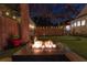 Relaxing backyard featuring a fire pit, putting green, mature trees and decorative string lights at 1523 1St W Ave, Bradenton, FL 34205
