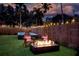 Cozy backyard with a fire pit, hot tub, wooden fence, and string lights for relaxation and entertaining at 1523 1St W Ave, Bradenton, FL 34205