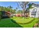 Backyard featuring a putting green, hot tub, deck, and mature trees providing shade at 1523 1St W Ave, Bradenton, FL 34205